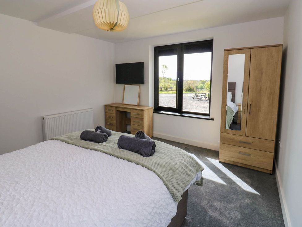 A bedroom with a bed and a desk at Oak Tree Cottage in Frizington