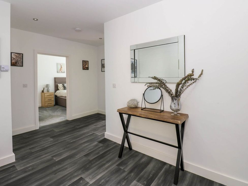 A hallway with a console table and decorative items at Oak Tree Cottage in Frizington
