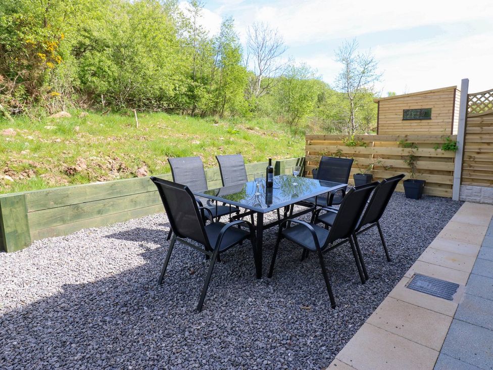 A garden with a table and chairs set at Oak Tree Cottage in Frizington