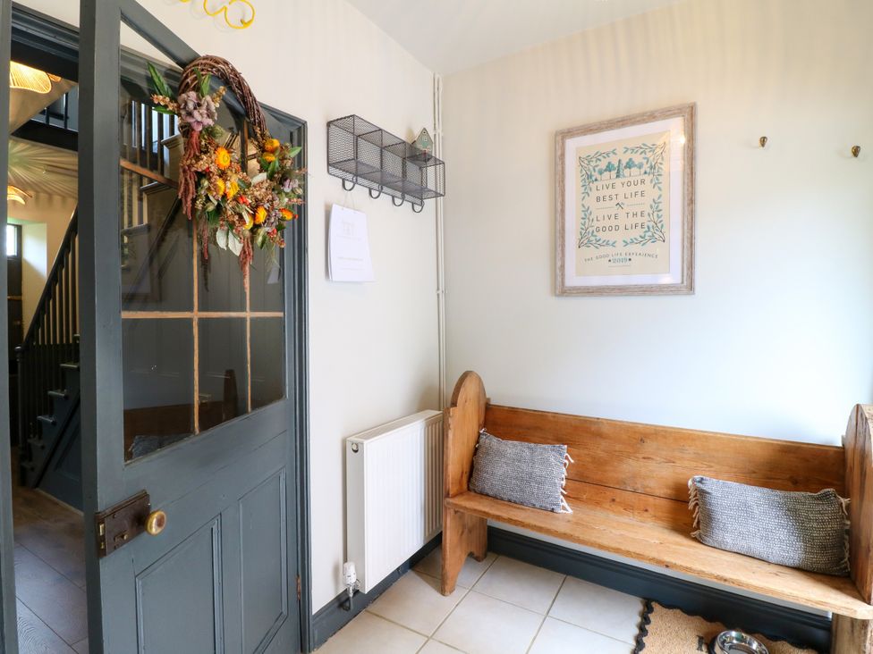 A hallway with a wooden bench and wall art at Haarlem House in Wirksworth