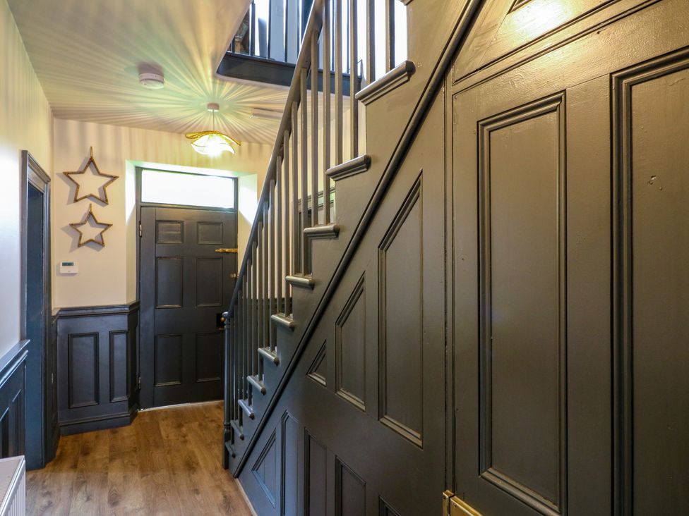 A hallway with a staircase and front door at Haarlem House in Wirksworth