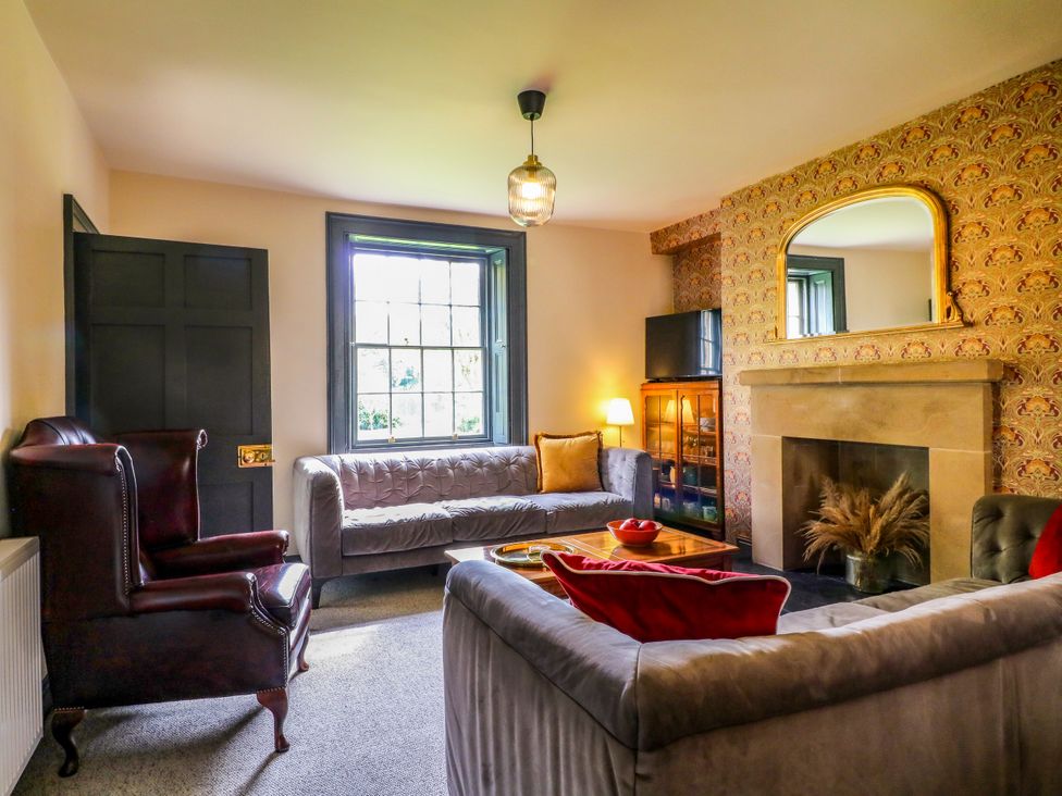A living room with a sofa, armchair, and coffee table at Haarlem House in Wirksworth