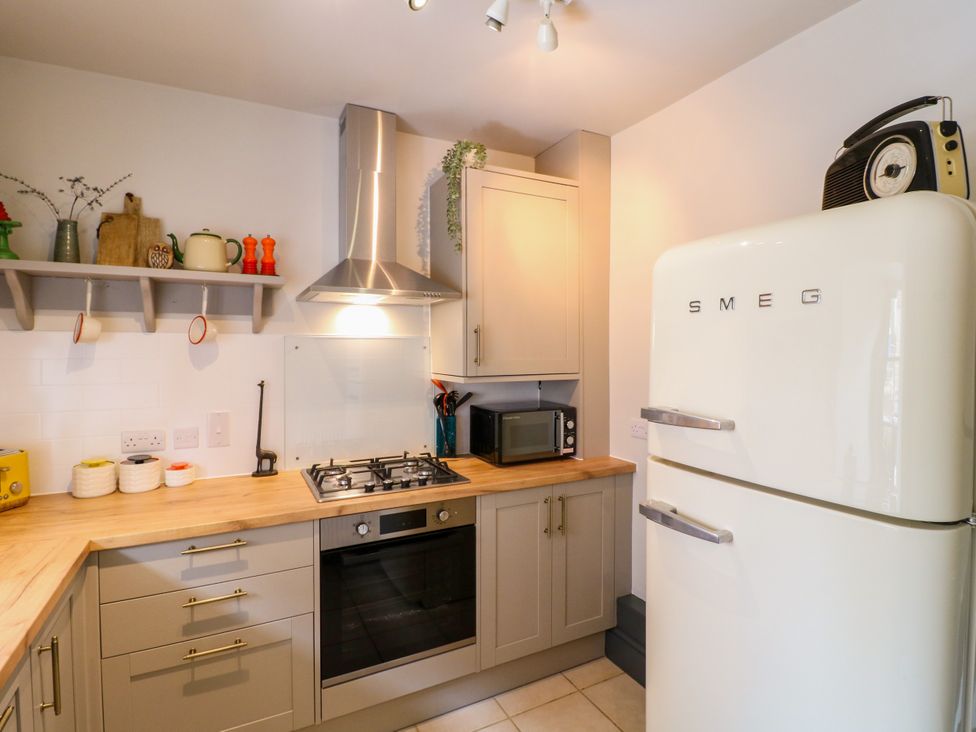 A kitchen with appliances and cabinets at Haarlem House in Wirksworth