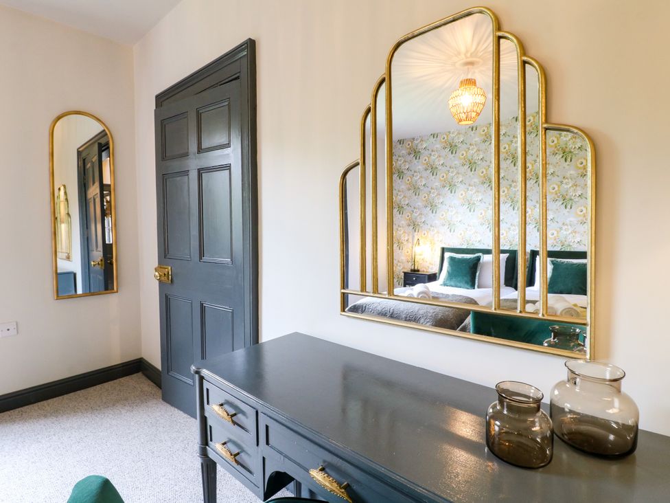A bedroom with a mirror and desk at Haarlem House in Wirksworth