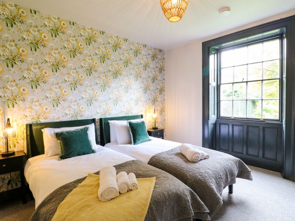 A bedroom with two beds and a window at Haarlem House in Wirksworth