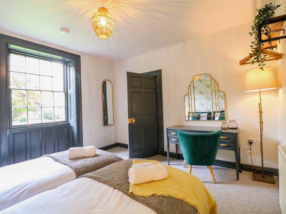 A bedroom with two beds and a desk at Haarlem House in Wirksworth