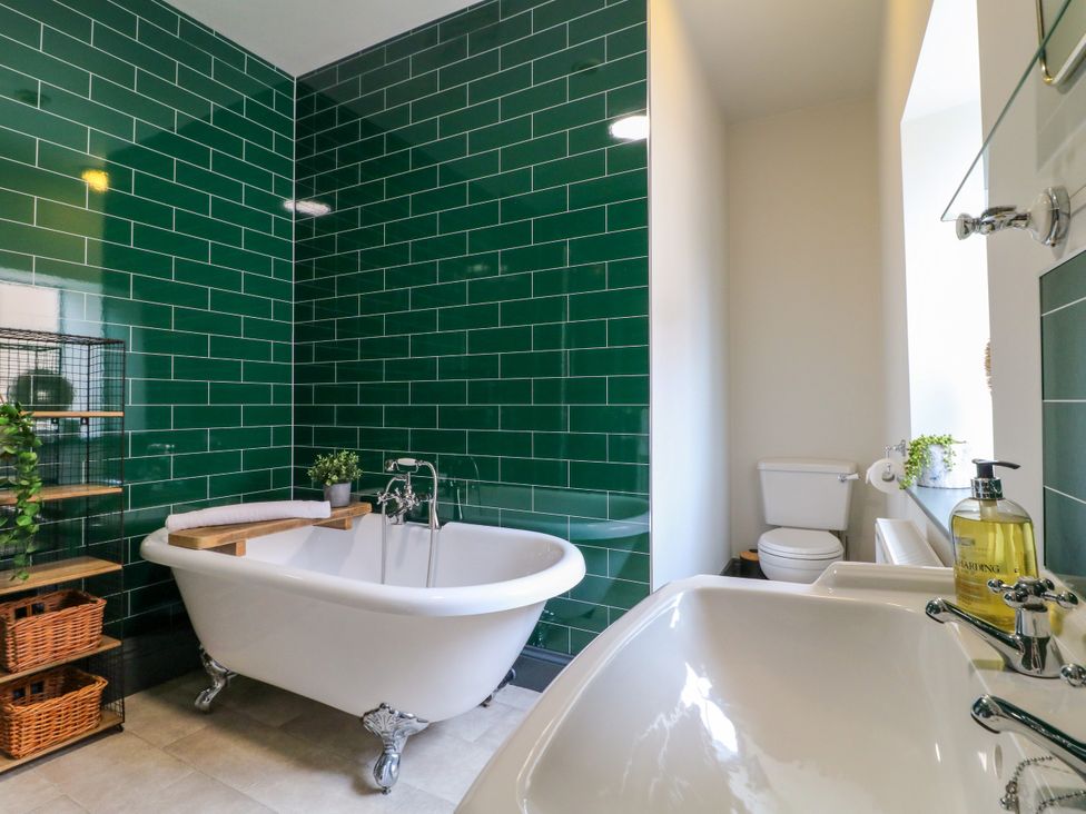 A bathroom with a bathtub, sink, and toilet at Haarlem House in Wirksworth