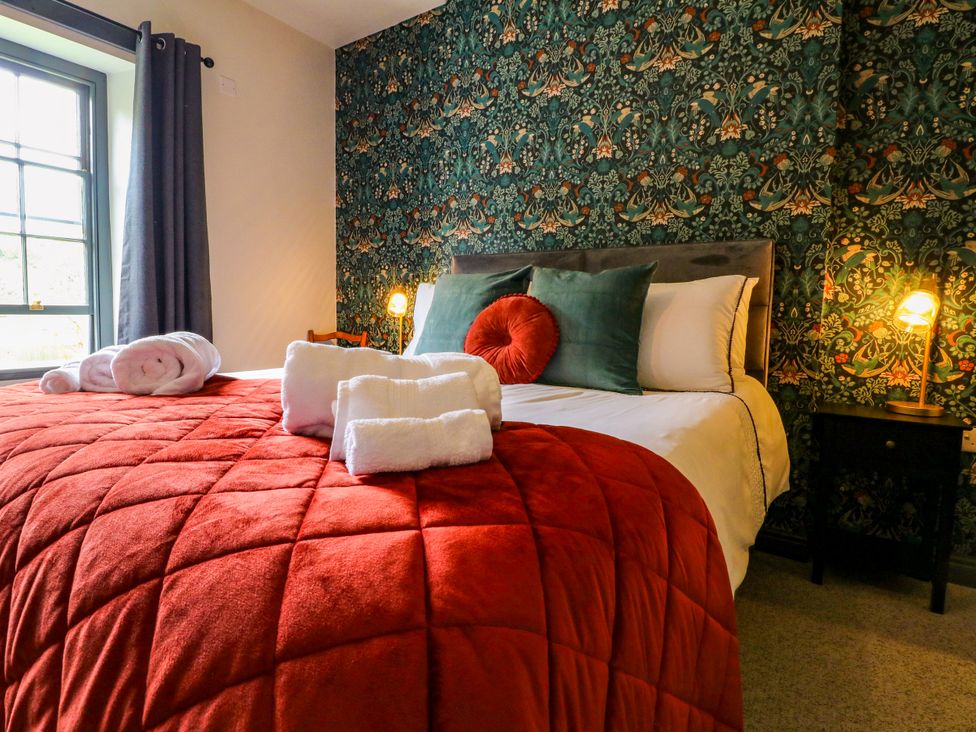 A bedroom with a bed, towels, and a lamp at Haarlem House in Wirksworth