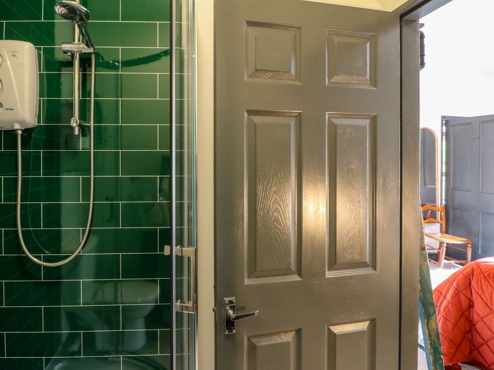 A bathroom with a shower and a doorway at Haarlem House in Wirksworth