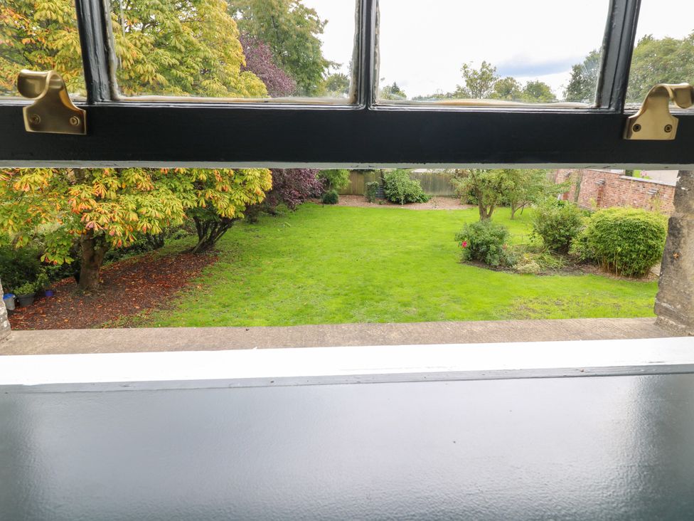 A view of a garden with trees and grass at Haarlem House in Wirksworth