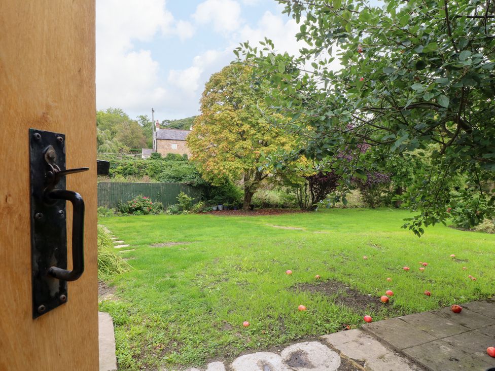 A view of a garden with trees and grass at Haarlem House in Wirksworth