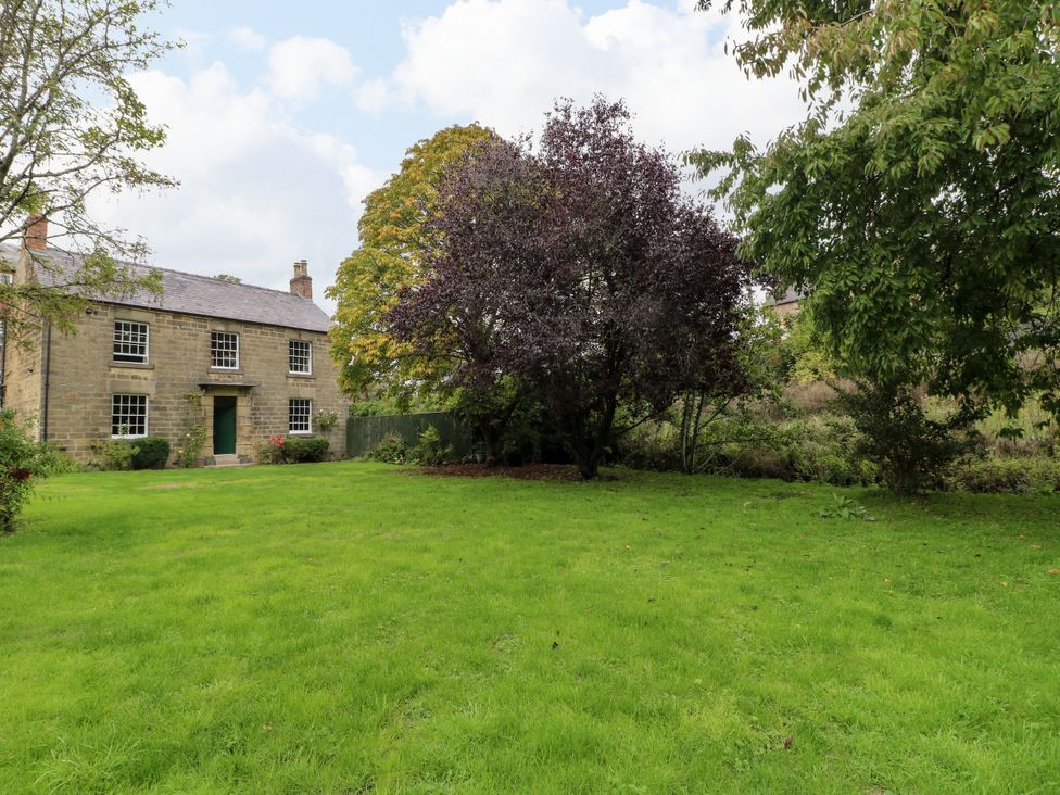 A house with trees and a lawn in the garden at Haarlem House in Wirksworth