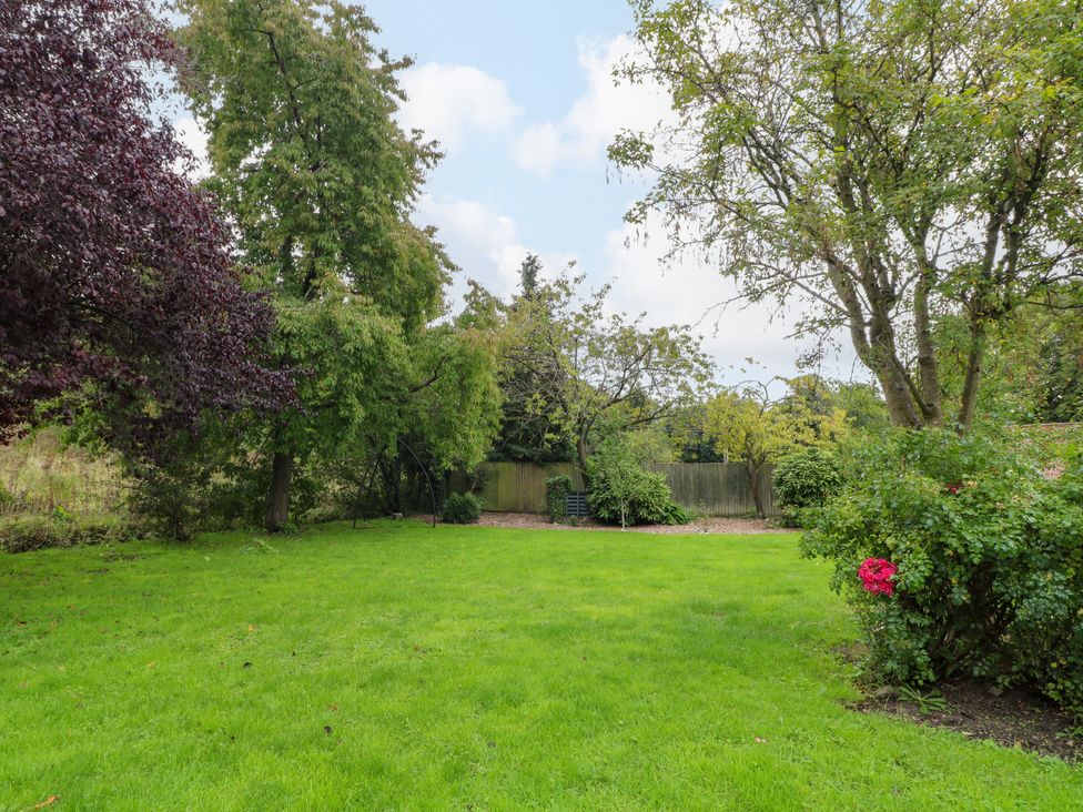 A garden area with grass and trees at Haarlem House in Wirksworth