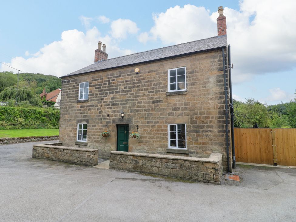 A stone house with windows and a green door at Haarlem House in Wirksworth