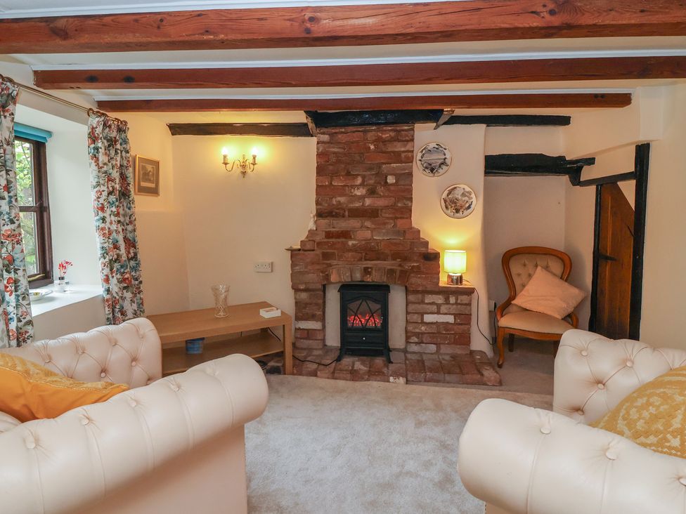A living room with a fireplace and a sofa at The Cottage in Bridgwater
