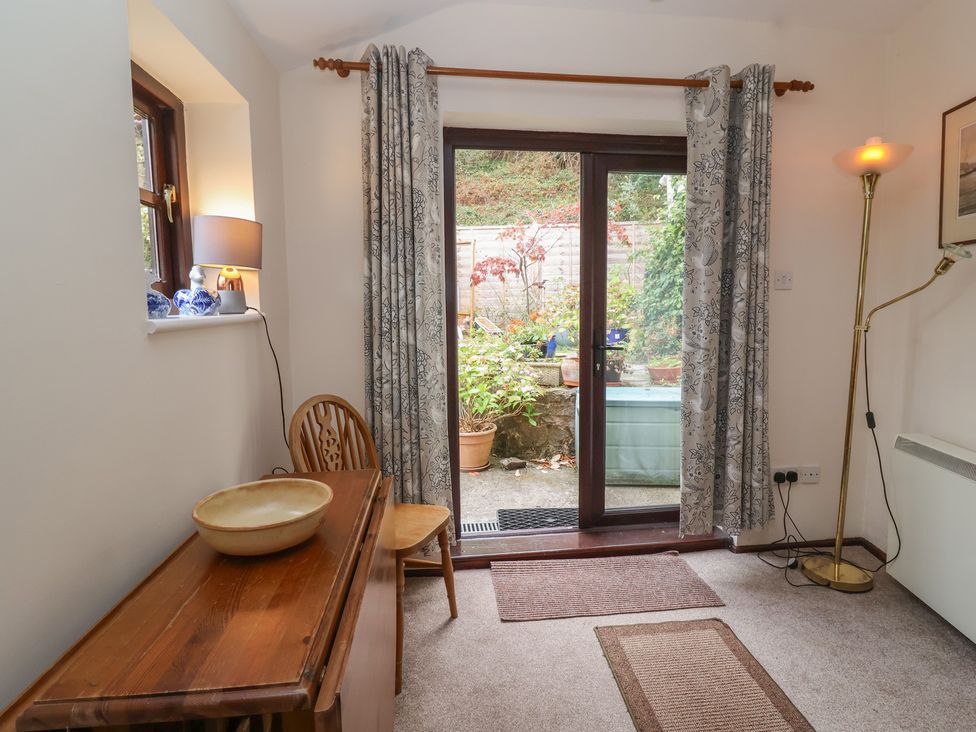 A snug with a table and a sliding door leading to a garden at The Cottage in Bridgwater