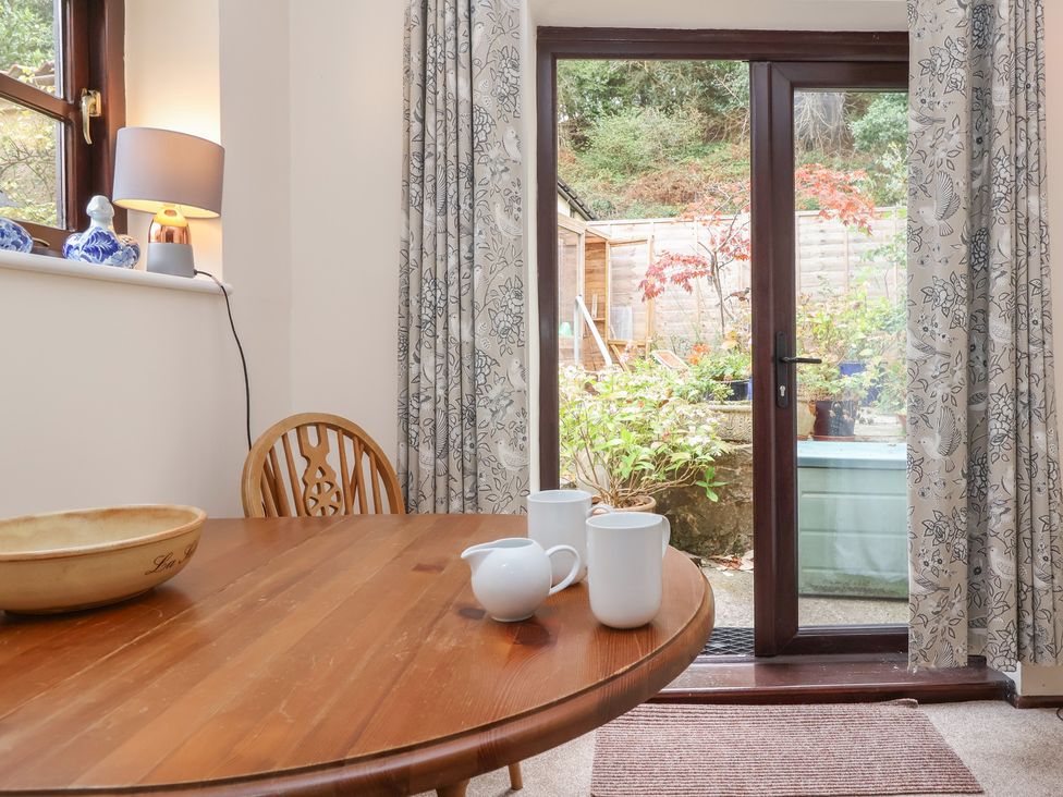 A dining room with a table and chairs overlooking a garden at The Cottage in Bridgwater