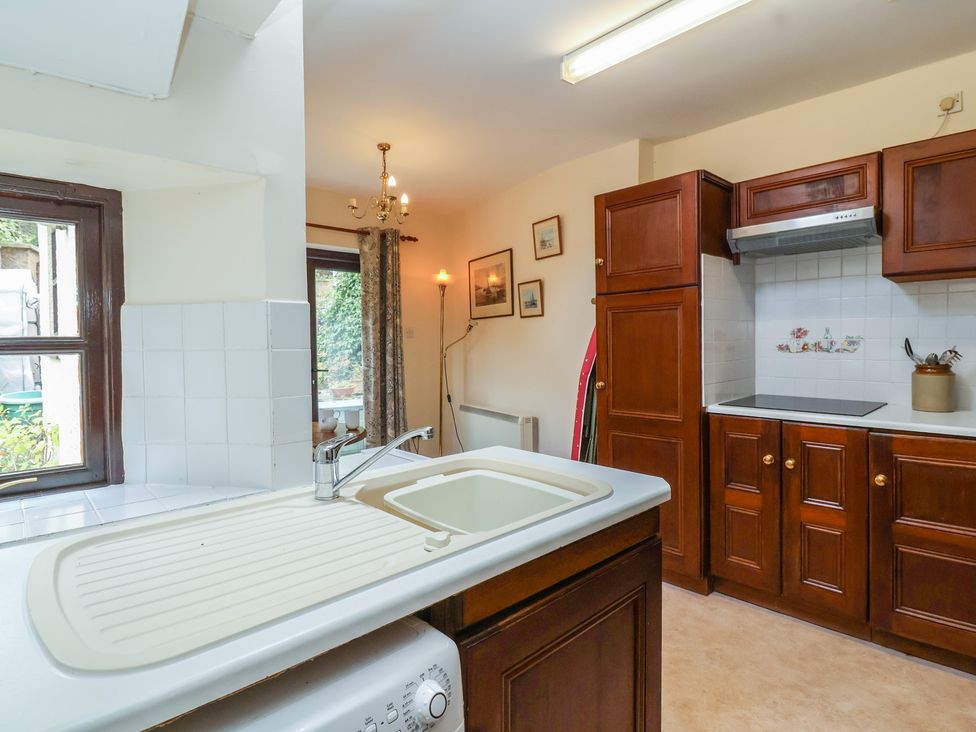 A kitchen with cabinets and sink at The Cottage in Bridgwater