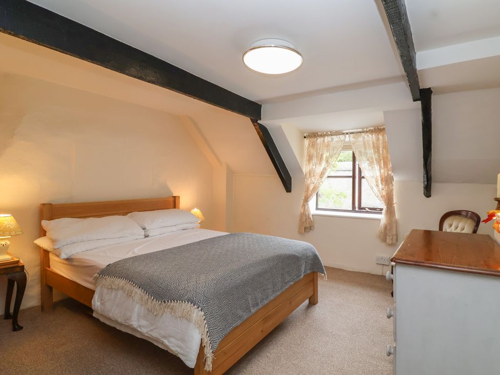 A bedroom with a bed and window at The Cottage in Bridgwater