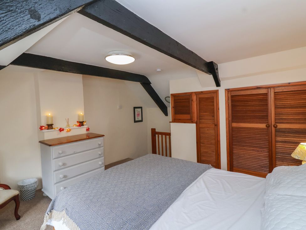 A bedroom with a bed and dresser at The Cottage in Bridgwater