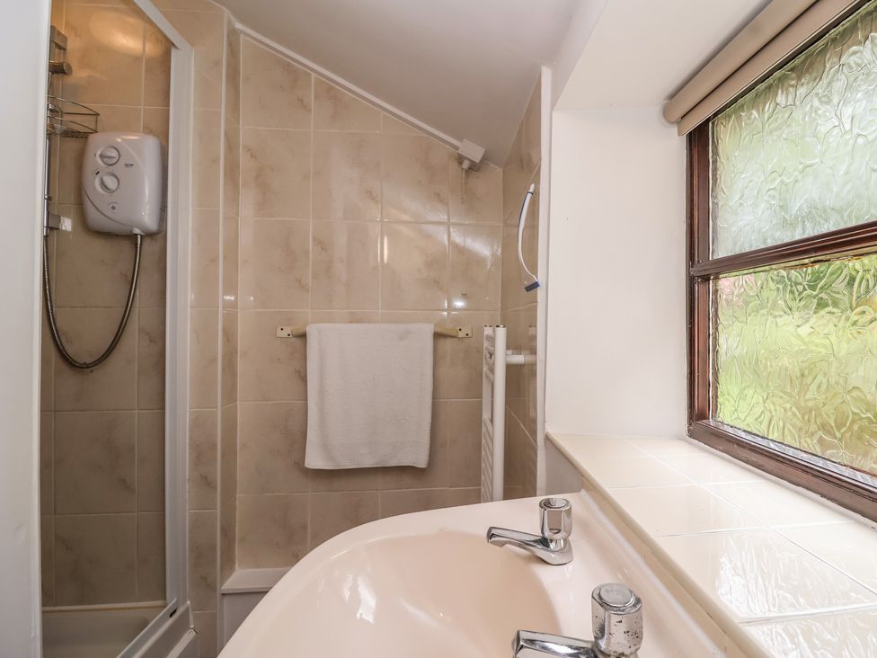 A bathroom with a shower and sink at The Cottage in Bridgwater