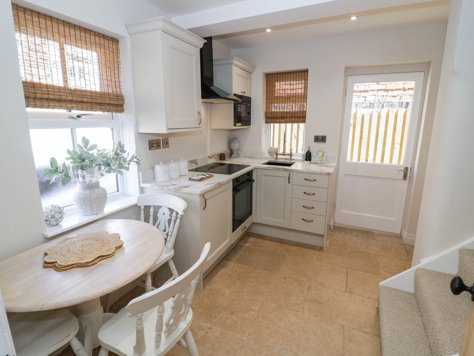 A kitchen with cabinets and a table at Albert Cottage in Stratford-upon-Avon