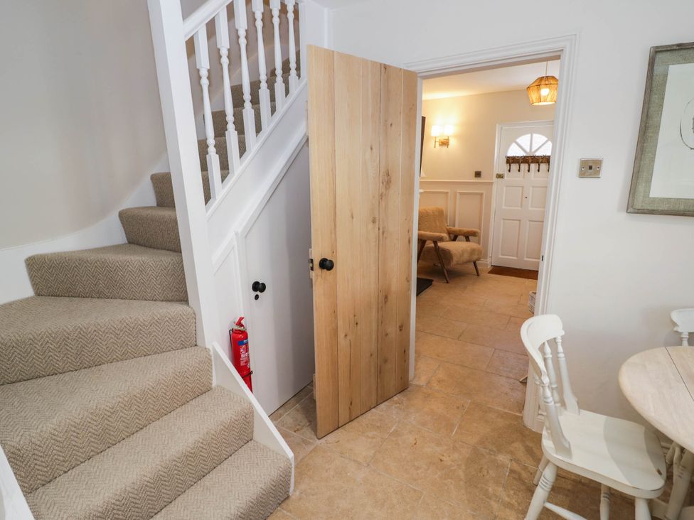 A hallway with a staircase and a door at Albert Cottage Stratford-upon-Avon