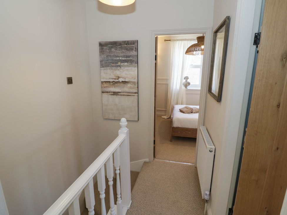 A hallway with a staircase and doorway to a bedroom at Albert Cottage Stratford-upon-Avon