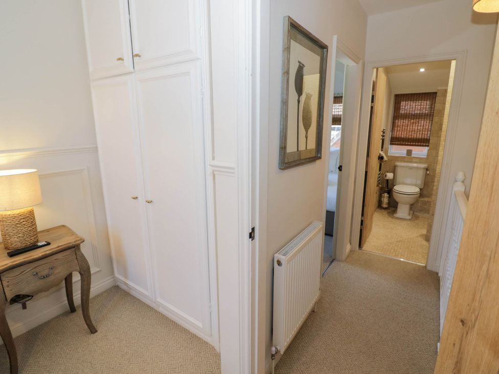 A hallway with a wardrobe and lamp at Albert Cottage Stratford-upon-Avon