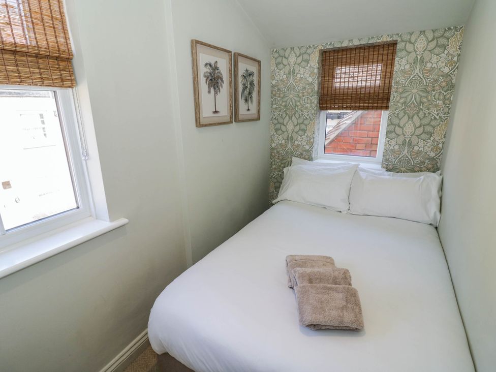 A bedroom with a bed and towels at Albert Cottage in Stratford-upon-Avon