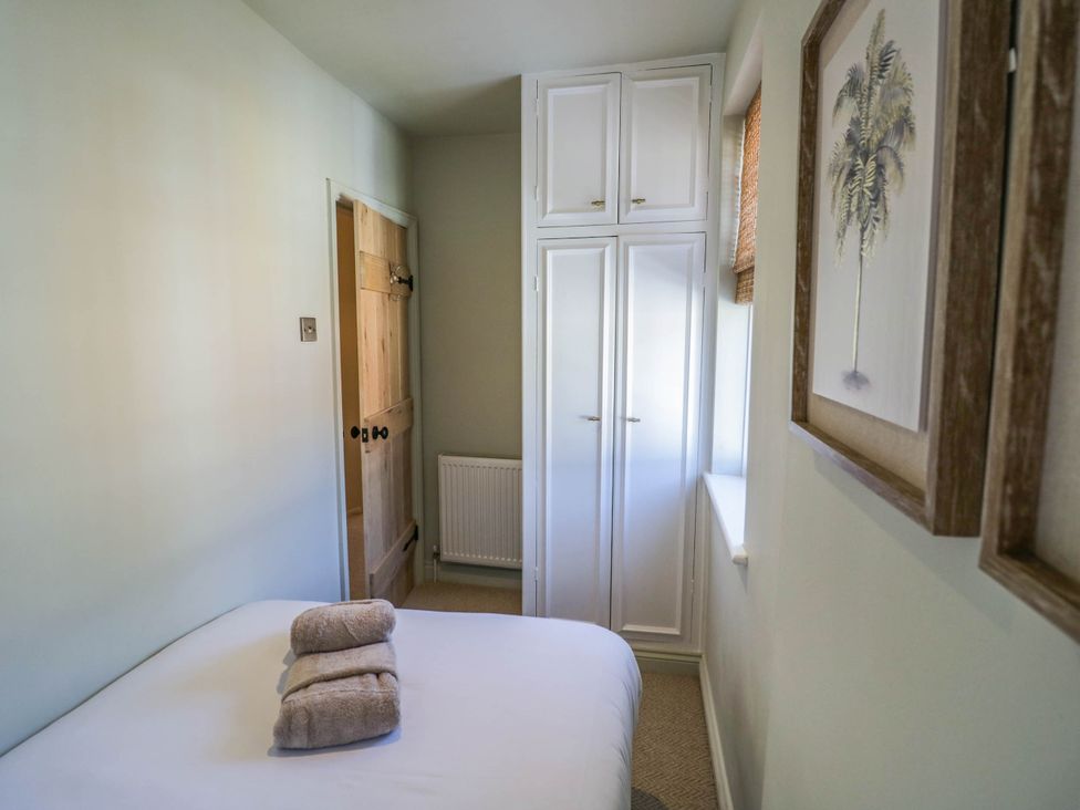 A bedroom with a bed and wardrobe at Albert Cottage in Stratford-upon-Avon