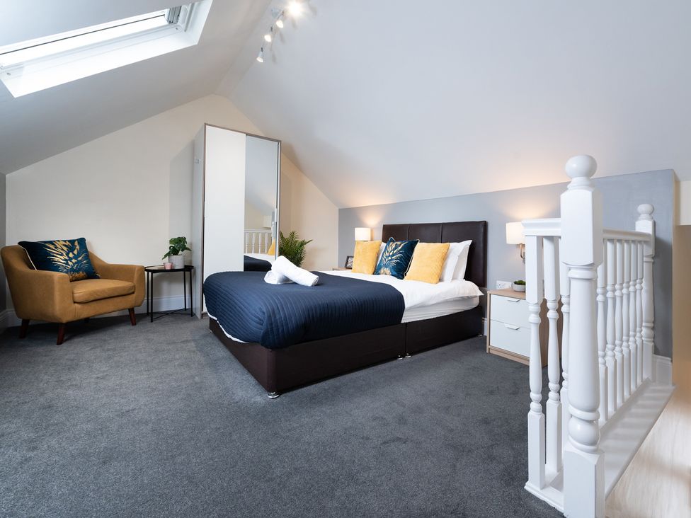 A bedroom with a bed and armchair at 38 Ashville Avenue, Scarborough