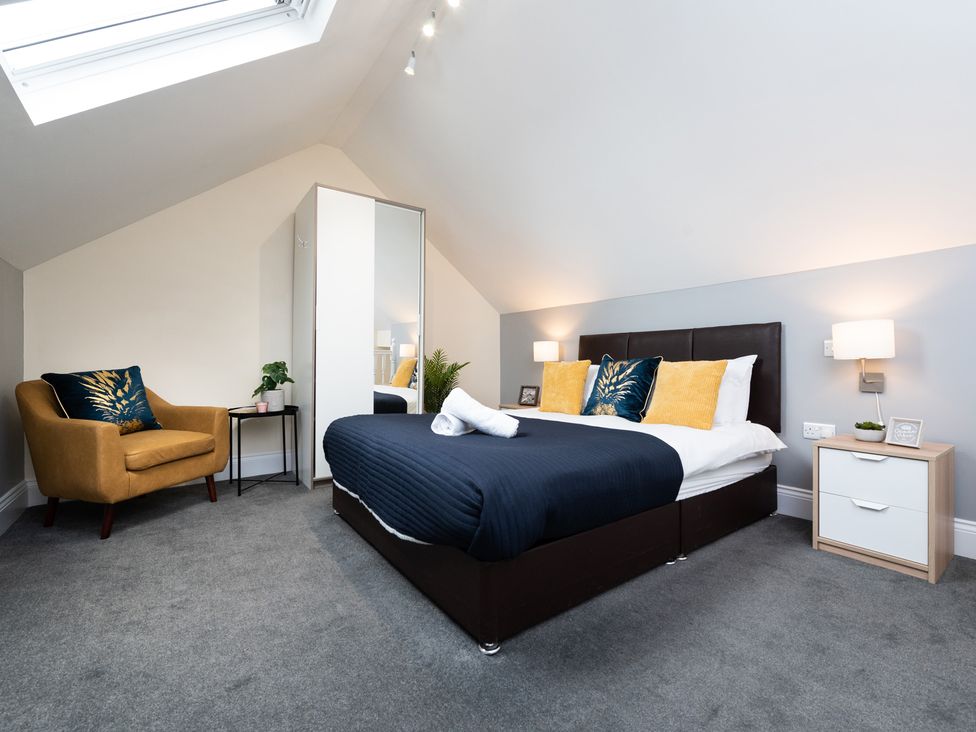 A bedroom with a bed and armchair at 38 Ashville Avenue, Scarborough