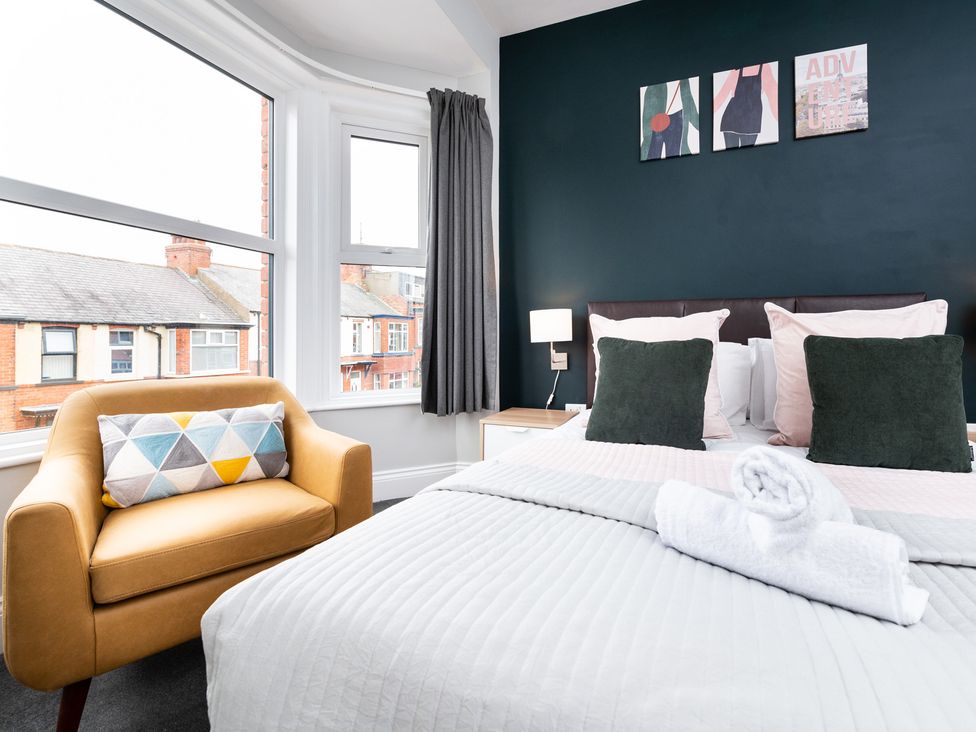 A bedroom with a bed, pillows, and a chair at 38 Ashville Avenue Scarborough