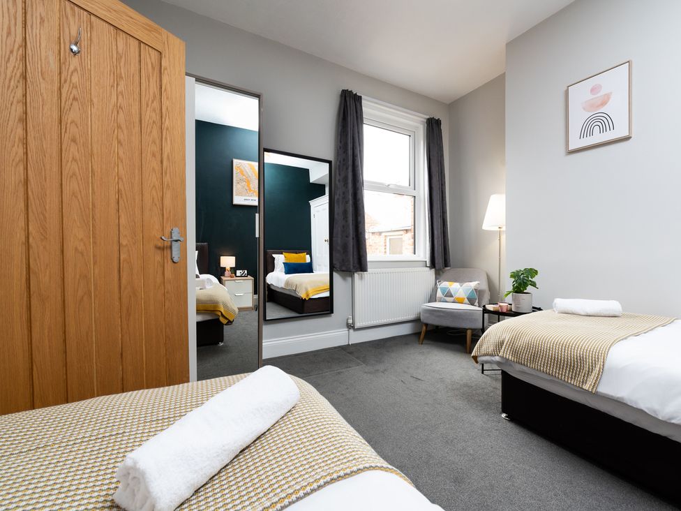 A bedroom with two beds and a mirror at 38 Ashville Avenue, Scarborough