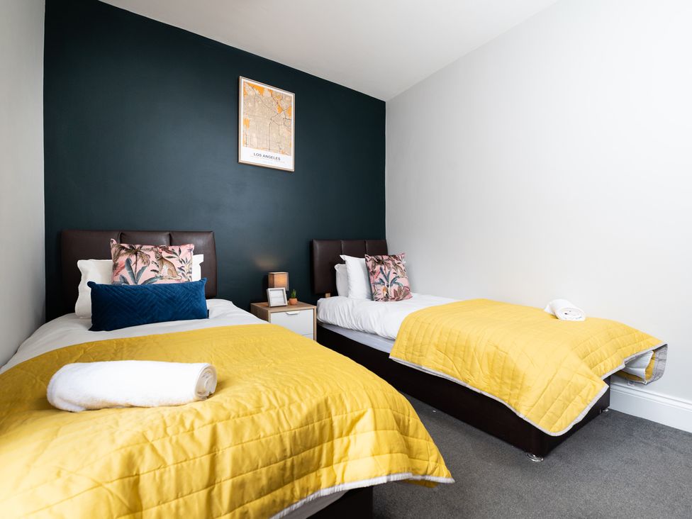 A bedroom with two beds and a nightstand at 38 Ashville Avenue, Scarborough