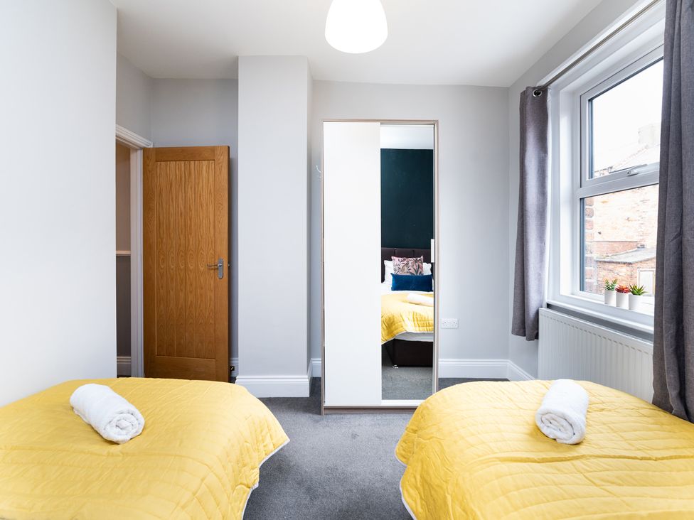 A bedroom with two beds and a mirror at 38 Ashville Avenue in Scarborough