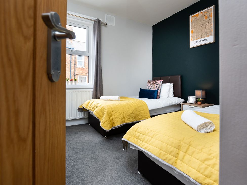A bedroom with two beds and a nightstand at 38 Ashville Avenue Scarborough