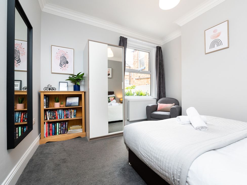 A bedroom with a bed, bookshelf, and mirror at 38 Ashville Avenue in Scarborough