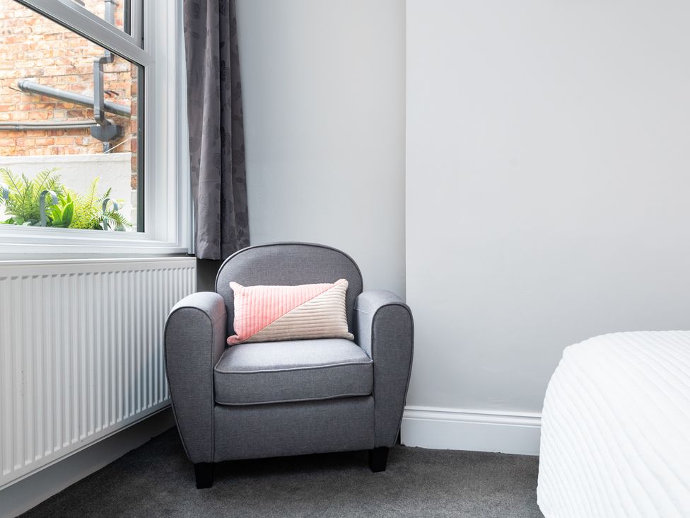 A bedroom with an armchair and window at 38 Ashville Avenue in Scarborough