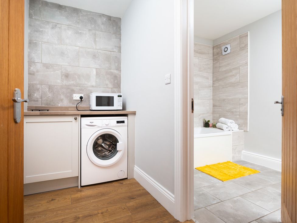 A laundry room with a washing machine and a microwave at 38 Ashville Avenue in Scarborough