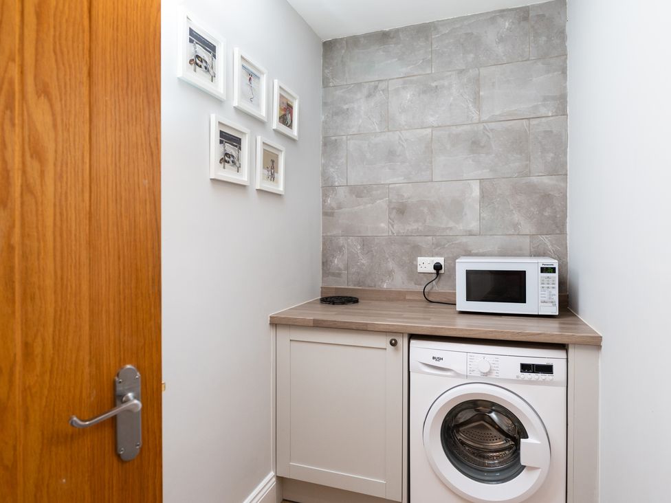A laundry room with a washing machine and microwave at 38 Ashville Avenue, Scarborough