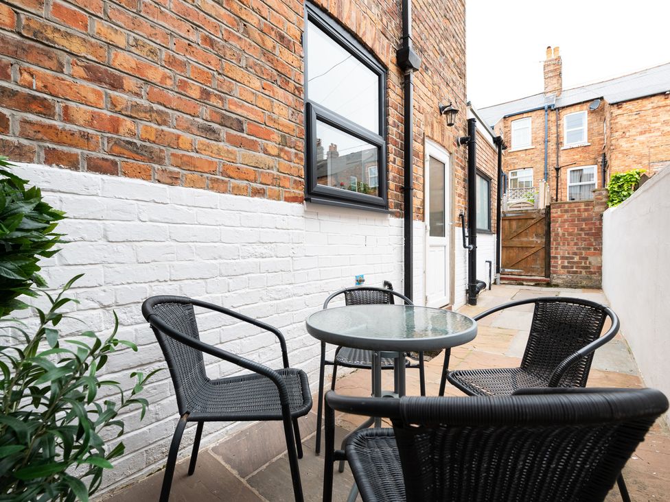 An outdoor patio with chairs and a glass table at 38 Ashville Avenue, Scarborough