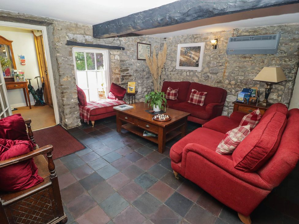 A living room with red sofas and a coffee table at Ty Mawr Country House in Carmarthen