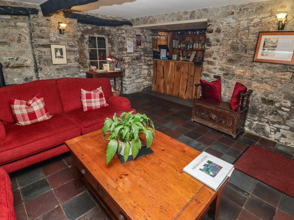 A living room with a sofa, coffee table and bar at Ty Mawr Country House, Carmarthen