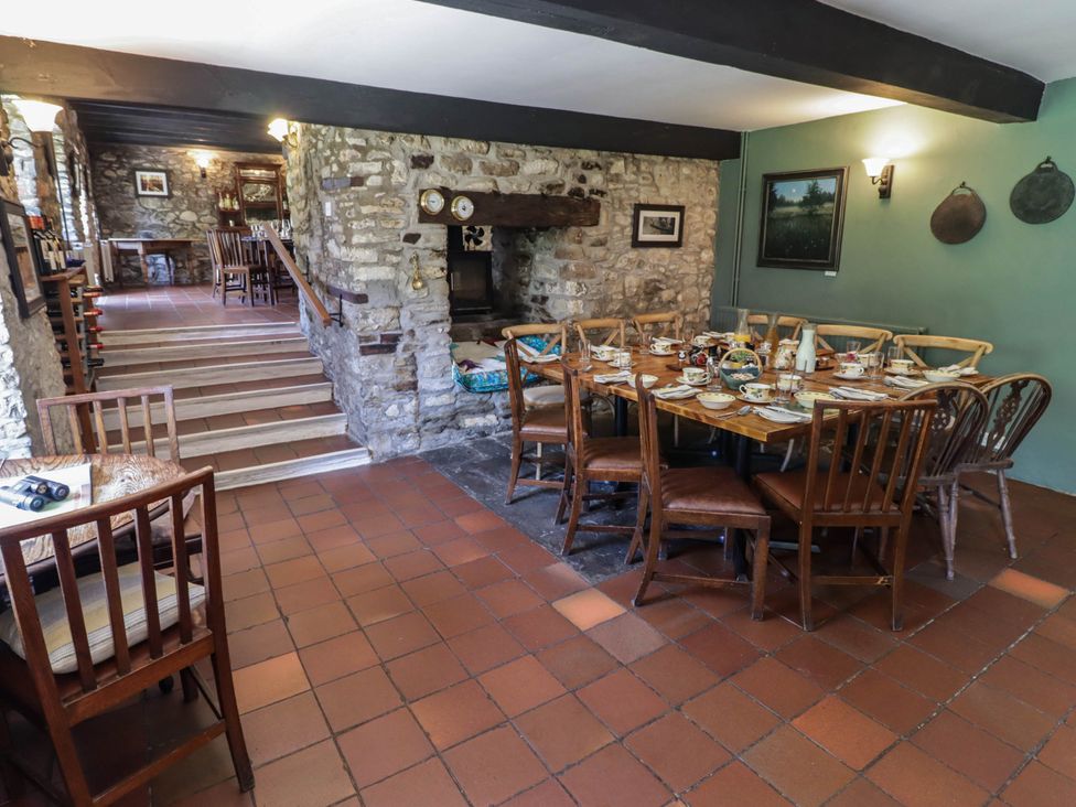 A dining room with a wooden table and chairs at Ty Mawr Country House in Carmarthen
