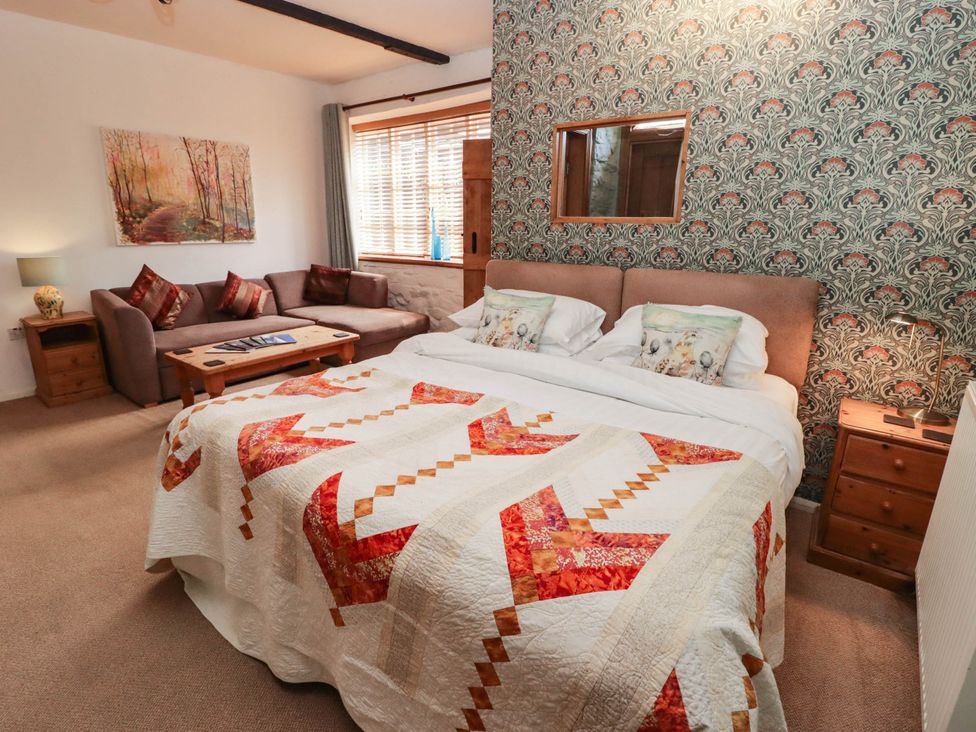 A bedroom with a bed, sofa and table at Ty Mawr Country House in Carmarthen