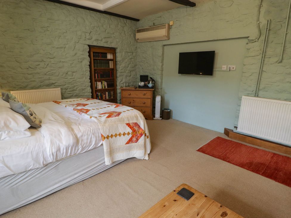 A bedroom with a bed and shelf at Ty Mawr Country House in Carmarthen