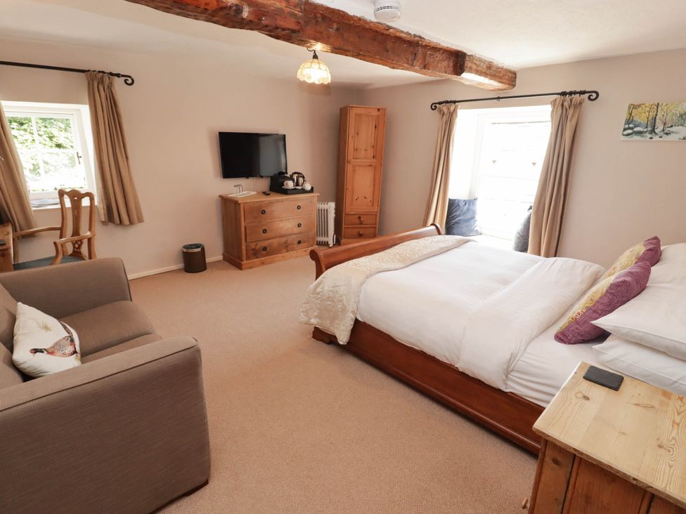 A bedroom with a bed and sofa at Ty Mawr Country House in Carmarthen