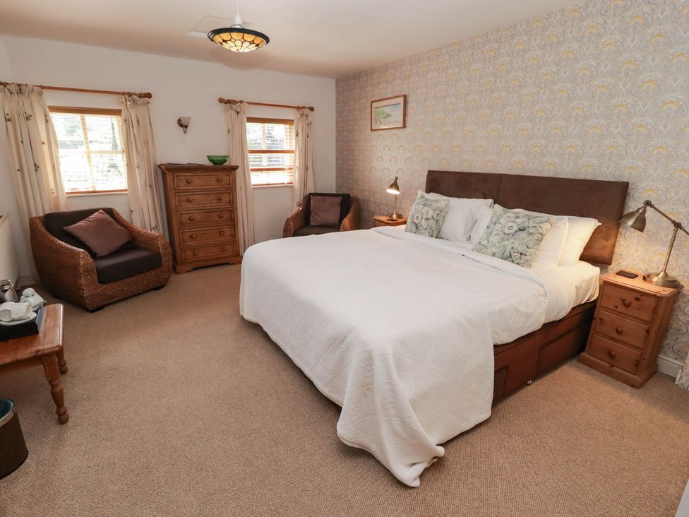 A bedroom with a bed and furniture at Ty Mawr Country House in Carmarthen